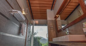 A modern bathroom with a glass shower enclosure, a white sink, and a wooden ceiling. - Bogala Village Eco Resort (Kotiyakumbura)