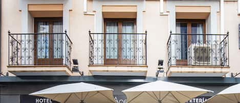 Un hotel con terraza, restaurante y varios balcones.