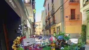 Un letrero para el restaurante El Acebo en una calle estrecha flanqueada por edificios.