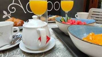 Colazione servita con croissant, succo d'arancia e teiera su un tavolo con il menu dell'Hotel Restaurante El Acebo.