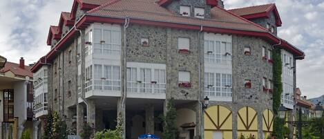 A stone building with multiple balconies and flower boxes.