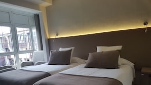 Una habitación de hotel con dos camas, una ventana y una silla.
