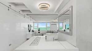 Een moderne, minimalistische badkamer met een grote spiegel, een witte wastafel en uitzicht op de omgeving.