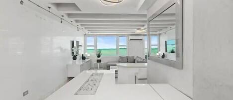 A modern, minimalist bathroom with a large mirror, a white vanity, and a view of the outdoors.