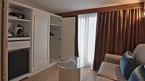 A compact room with a glass-top table, a sofa, a wardrobe, and a shower area. - Bergamo Inn (Bergamo)