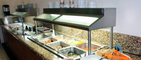 A buffet setup with various food stations and condiments.