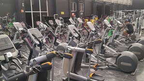 Une salle de sport équipée de plusieurs tapis de course, de machines de musculation et d’une variété d’appareils de fitness.