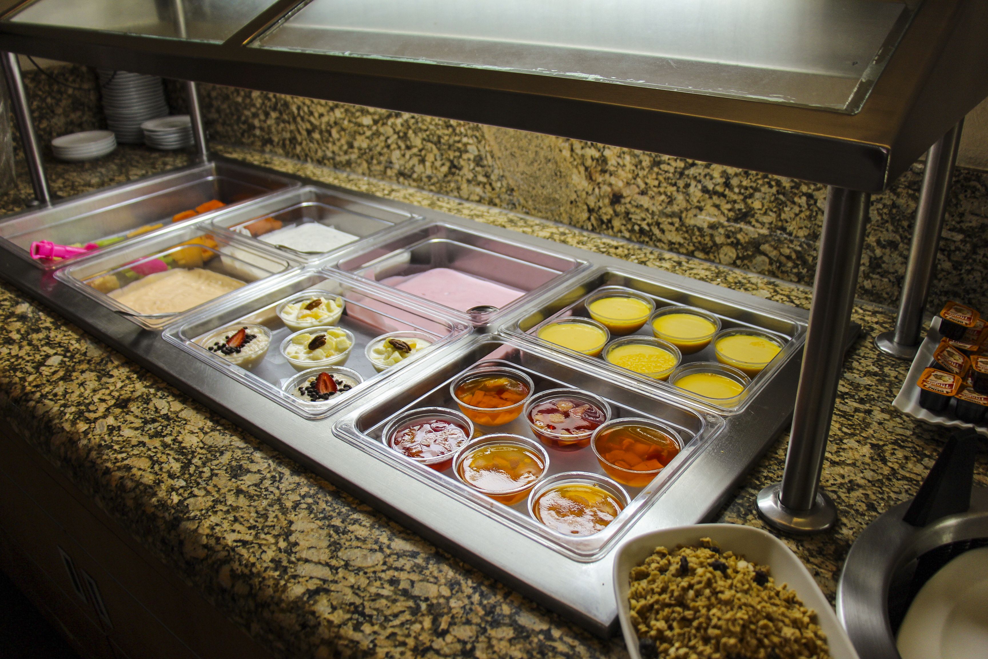 A buffet with various food items in separate containers.