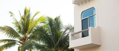 A white building with a balcony and a window.