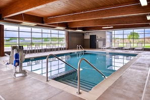 A swimming pool with clear blue water, surrounded by lounge chairs and a wooden ceiling. - Country Inn & Suites by Radisson, Ft. Atkinson, WI (Fort Atkinson)