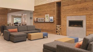 A modern living area with a sectional sofa, ottomans, and a fireplace. - Country Inn & Suites by Radisson, Ft. Atkinson, WI (Fort Atkinson)