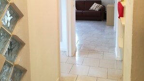 A hallway leading to a living area with a sofa and a red chair. - Pisolo home holidays near city center and Sant'Orsola Hospital (Bologna)