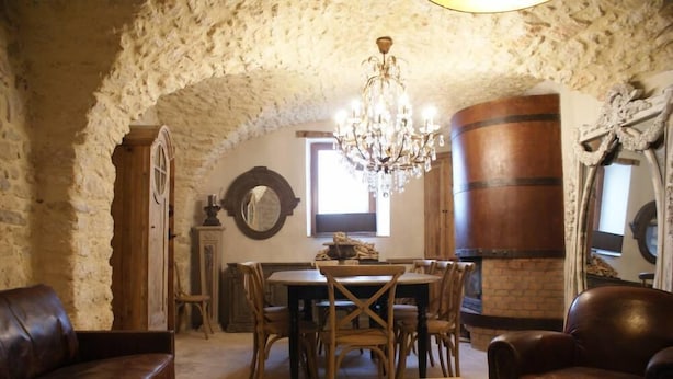 A rustic dining area with a wooden table, chairs, and a chandelier. - Mansion - Vallon pont d''arc (Vallon-Pont-D'arc)