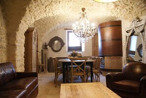 A rustic dining area with a wooden table, chairs, and a chandelier.