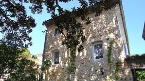 A stone building with ivy growth, a window, and a door. - Mansion - Vallon pont d''arc (Vallon-Pont-D'arc)