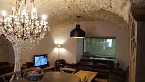 A cozy living room with a chandelier, a television, and a large window. - Mansion - Vallon pont d''arc (Vallon-Pont-D'arc)