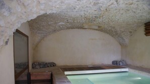 A stone-walled room with a small pool and a wooden bench. - Mansion - Vallon pont d''arc (Vallon-Pont-D'arc)