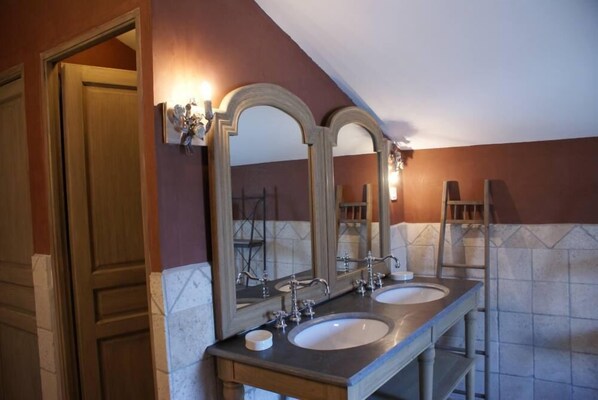 A bathroom with two sinks, a large mirror, and a wooden door.