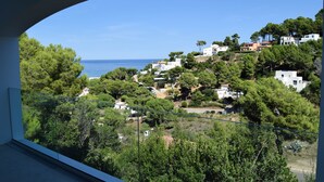 A coastal town with buildings on a hillside, a clear sky, and the sea in the background.