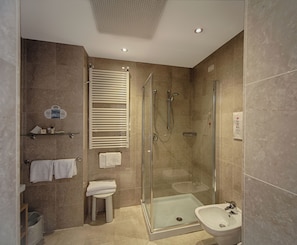 A modern bathroom with a glass-enclosed shower, a pedestal sink, and a toilet. - Duomo Hotel (Toscolano Maderno)