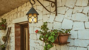 A stone wall with a hanging lantern and potted plants. - Villa 'Oasis' with exclusive pool (Siracusa)