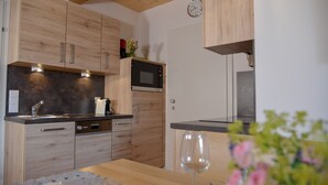 Una cocina moderna con armarios de madera, microondas integrado y un fregadero.