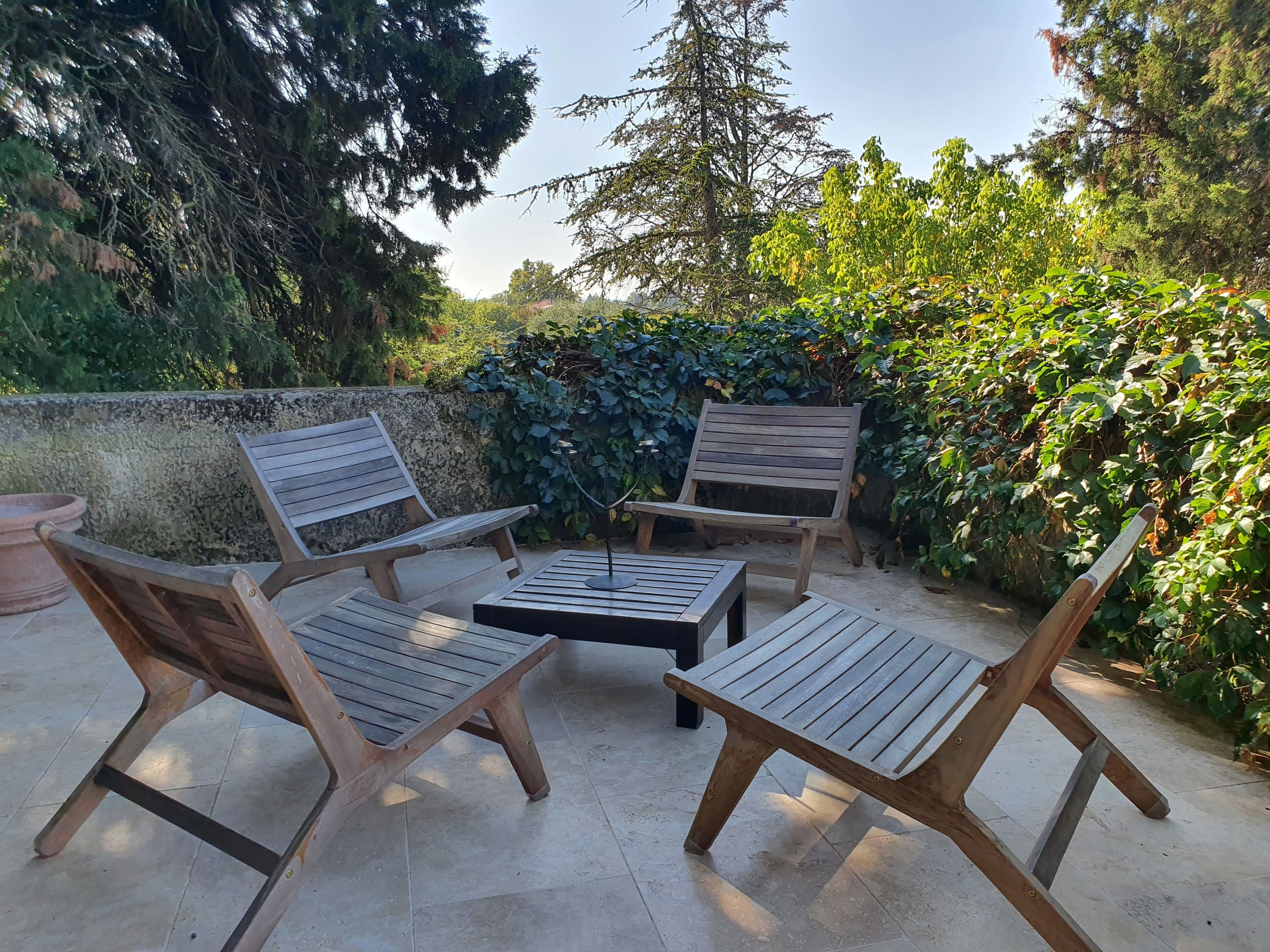 A patio area with wooden furniture including two chairs and a small table.