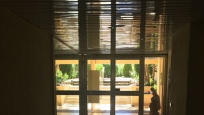 A hallway with a glass door leading to an outdoor area with steps and greenery. - Magnifique appartement dominant de 100m2, énorme terrasse vue mer et montagne (Vence)