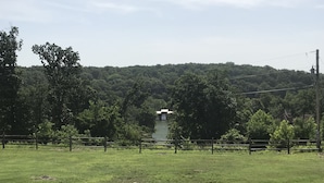 A grassy field with a wooden fence and trees. - HEATED POOL  Grand Serenity is your Oasis on South Grand (Afton)