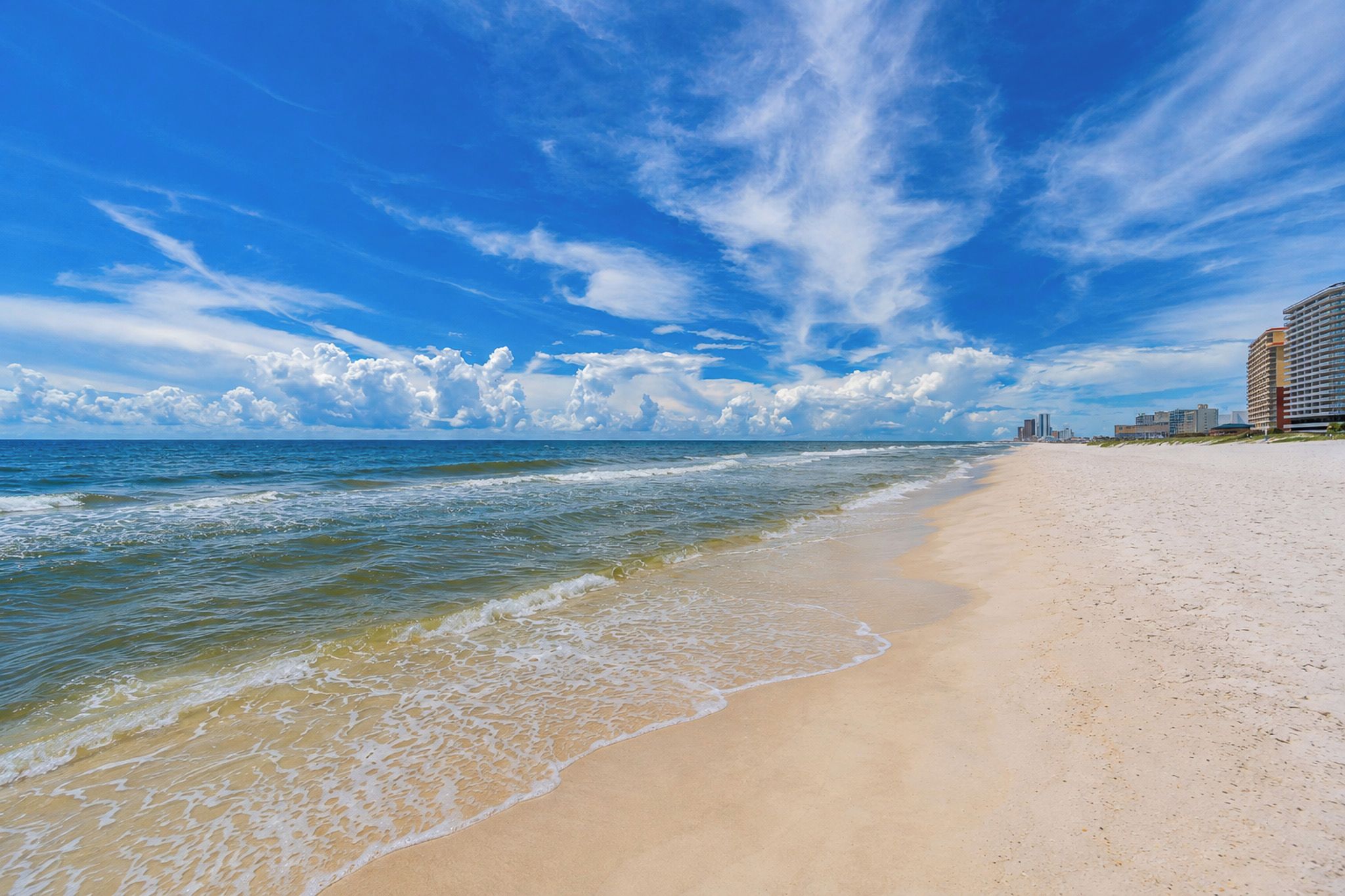 A beach with a clear sky and ocean waves.