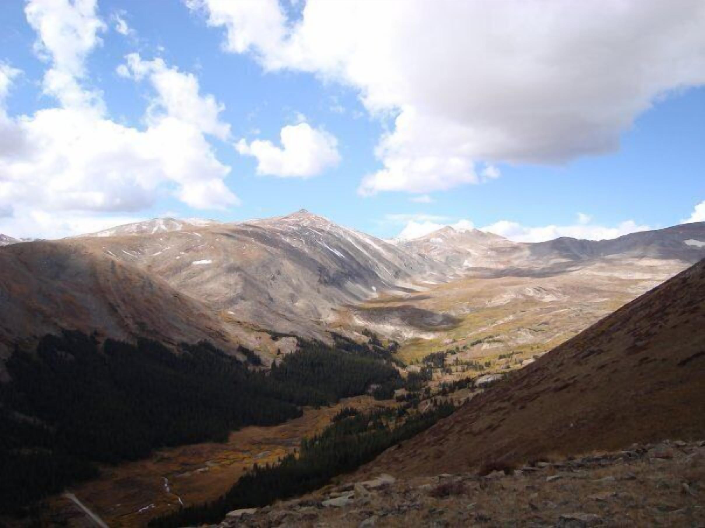 A mountainous landscape with a valley and a clear sky.
