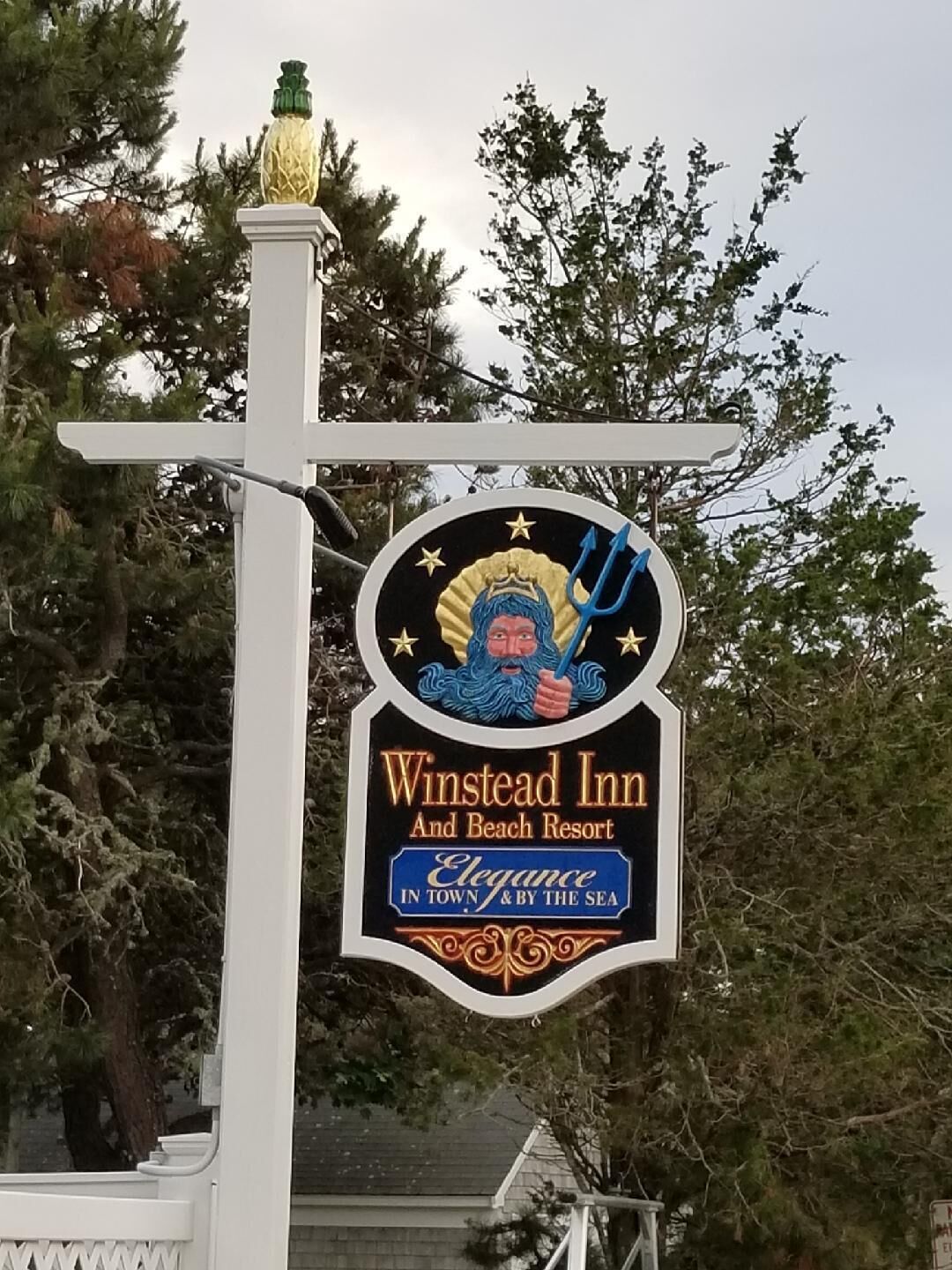 Un letrero para Winstead Inn and Beach Resort con un emblema decorativo.