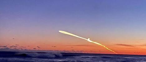 Un atardecer sobre el océano con una estela visible.