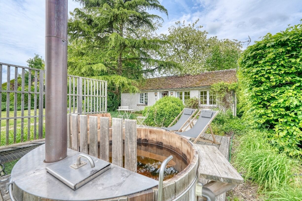 A spa area with a hot tub, wooden deck, and lounge chairs.