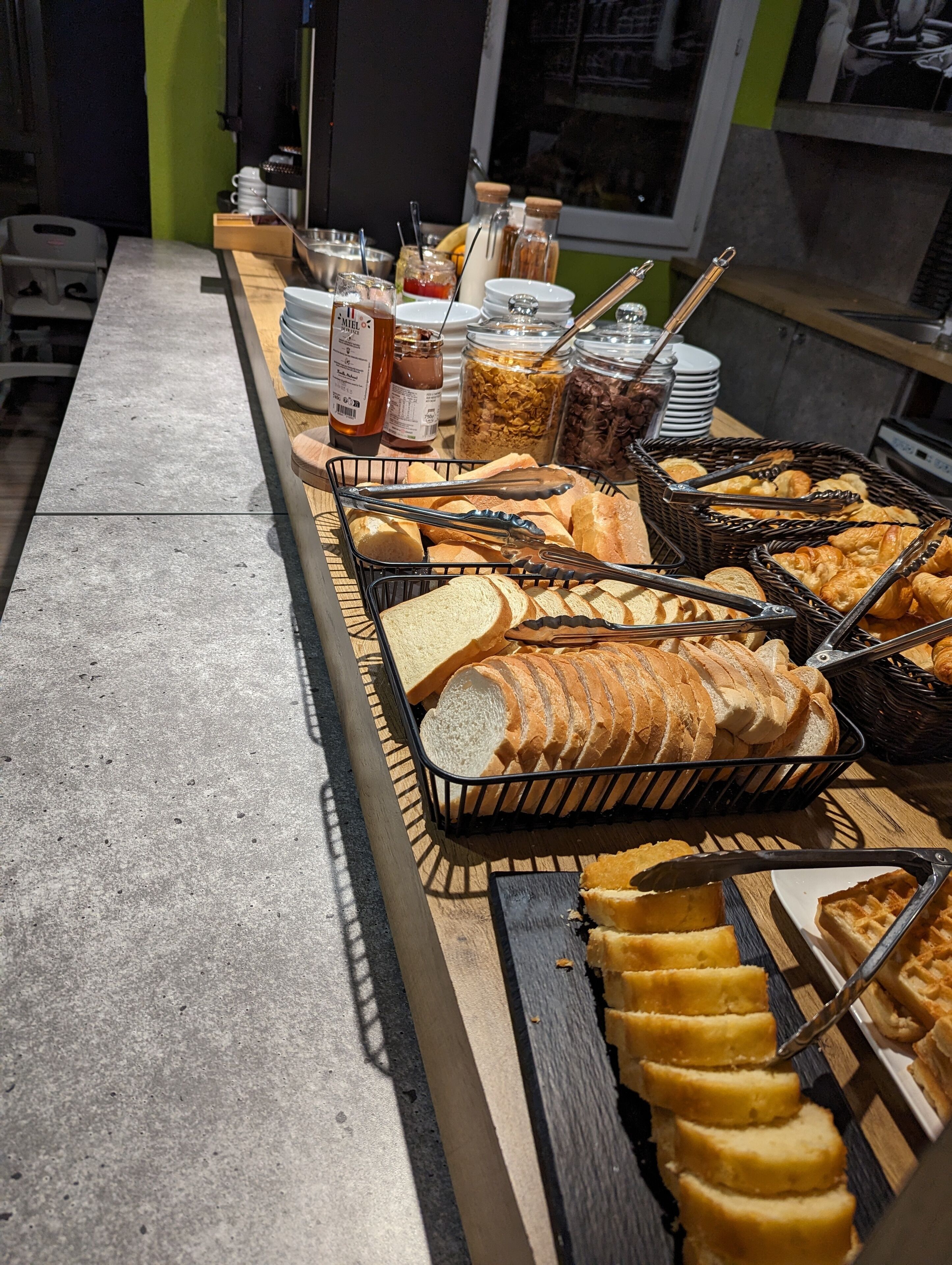 Un bufé con panes, pasteles y acompañamientos varios.