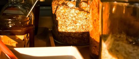 A kitchen with a coffee maker, a jar of oats, and a container of sugar.