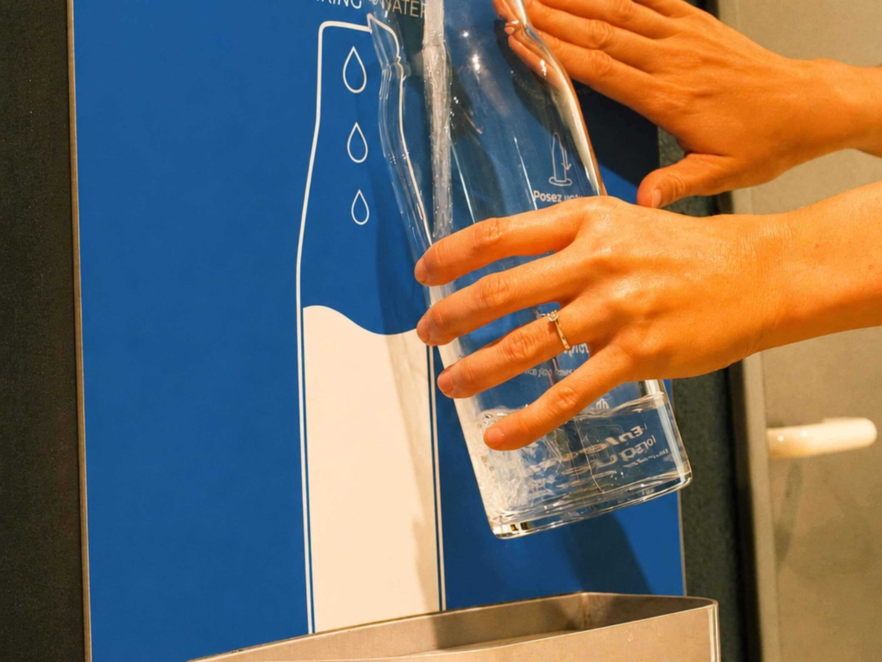 A hand dispensing water from a dispenser.