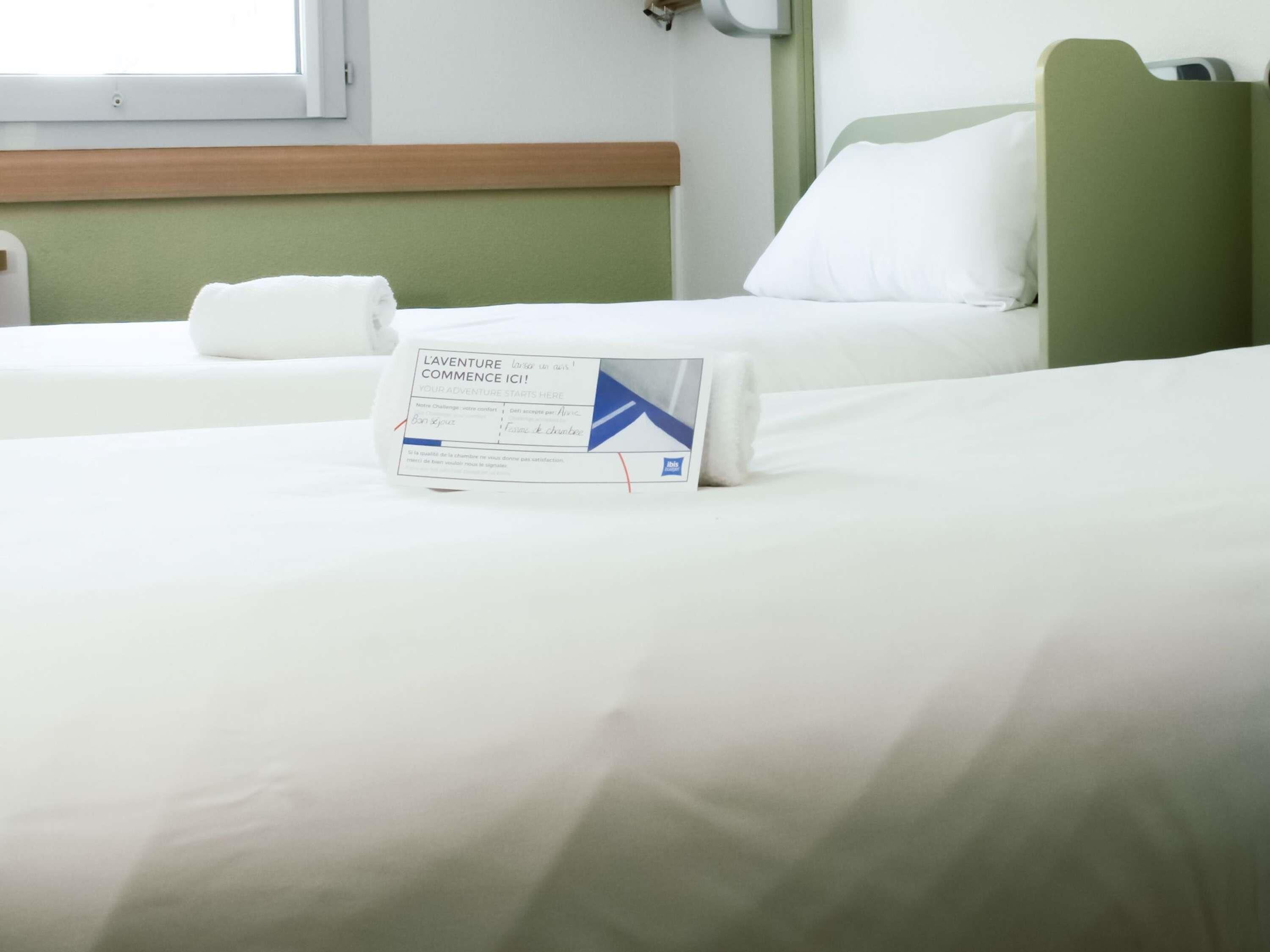 Une chambre d’hôtel avec un lit, un oreiller, une table de chevet et une fenêtre.