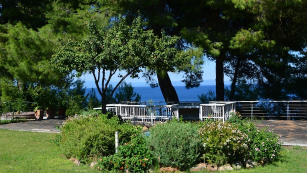 A gazebo with a metal railing, surrounded by lush greenery and a view of the sea. - Luxury Maisonette in Halkidiki (Kassandra)