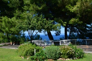 A gazebo with a metal railing, surrounded by lush greenery and a view of the sea. - Luxury Maisonette in Halkidiki (Kassandra)