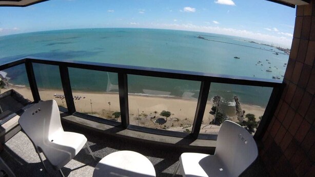 Een balkon met uitzicht op het strand en de oceaan.