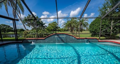 Airy house with heated waterfall pool overseeing golf course, minutes from beach