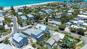 A coastal residential area with multiple two-story houses, a beach, and clear blue skies.