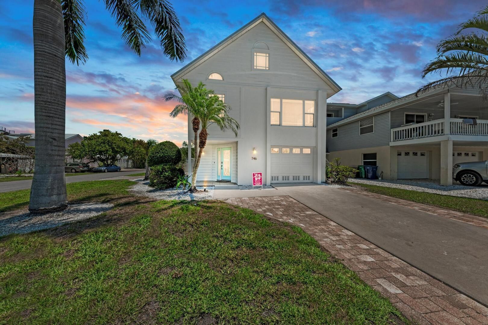 A two-story house with a front porch, a garage, and a driveway.