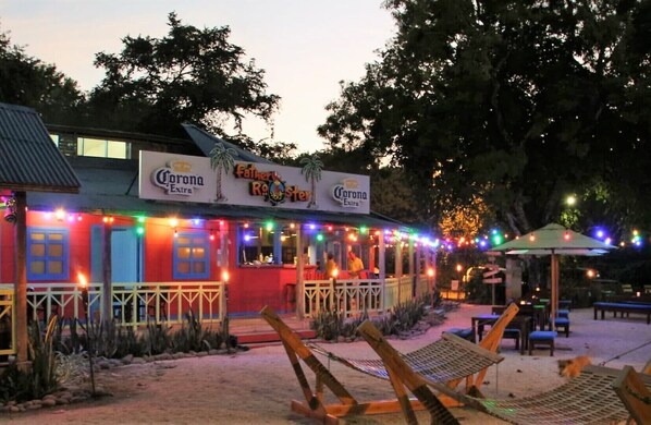 A restaurant with outdoor seating and string lights.