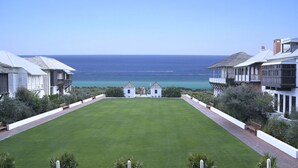 Ein gepflegter Rasen mit Blick aufs Meer, umgeben von Gebäuden mit Balkonen.