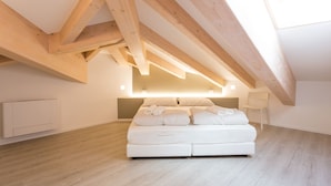 Un dormitorio con una cama grande, vigas de madera y un diseño moderno.