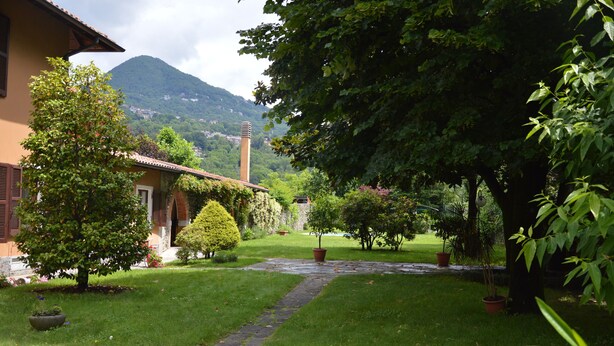 Ein Gartenweg führt zu einem Haus mit Blick auf die Berge.