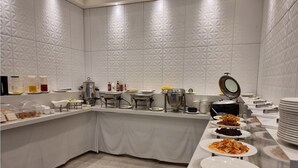 Una barra de buffet con diferentes alimentos y utensilios para servir.