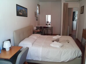 A hotel room with a bed, a desk, a chair, a lamp, and a picture on the wall. - Apartment with 6 beds on the top floor with elevator (Firenze)